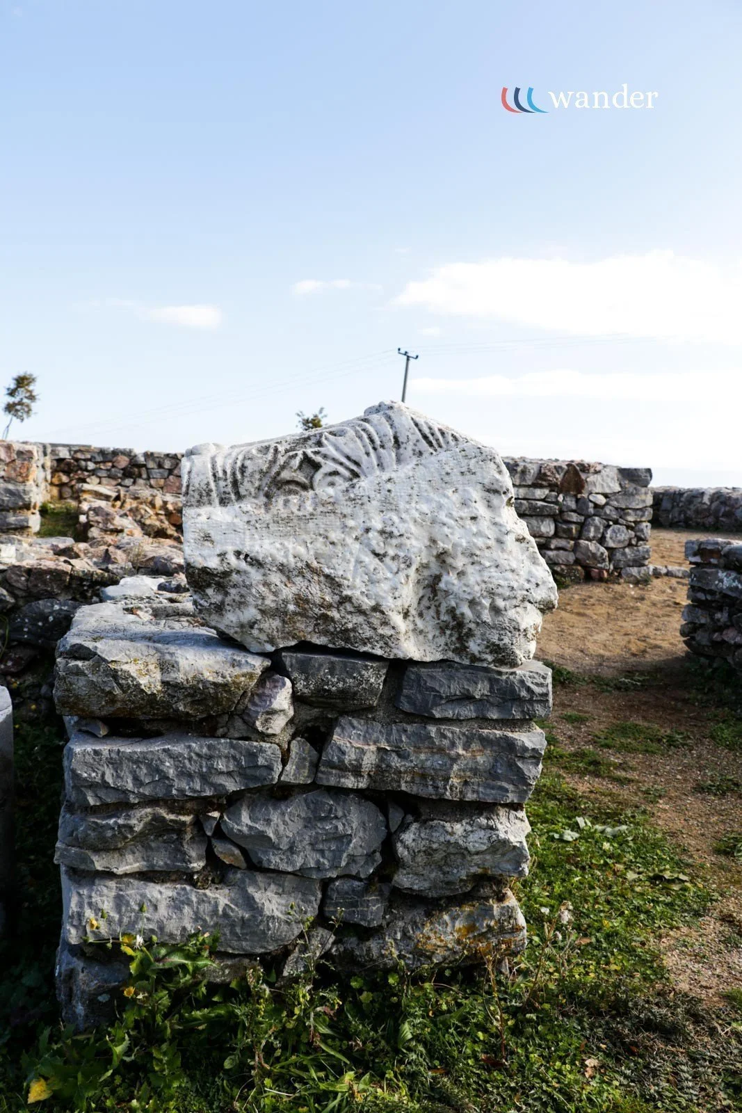 Close-up of ancient stone sculptures and ruins outdoors on a sunny day.