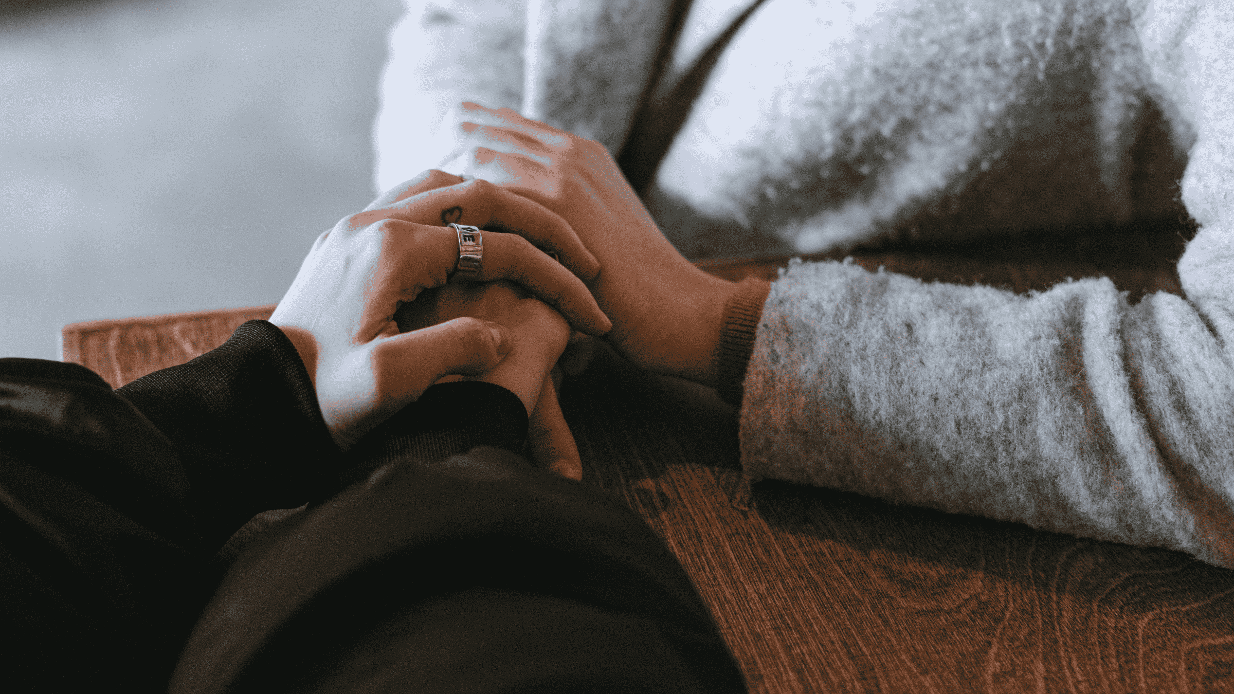 Death doula holding hands with a dying person's loved one while they grieve