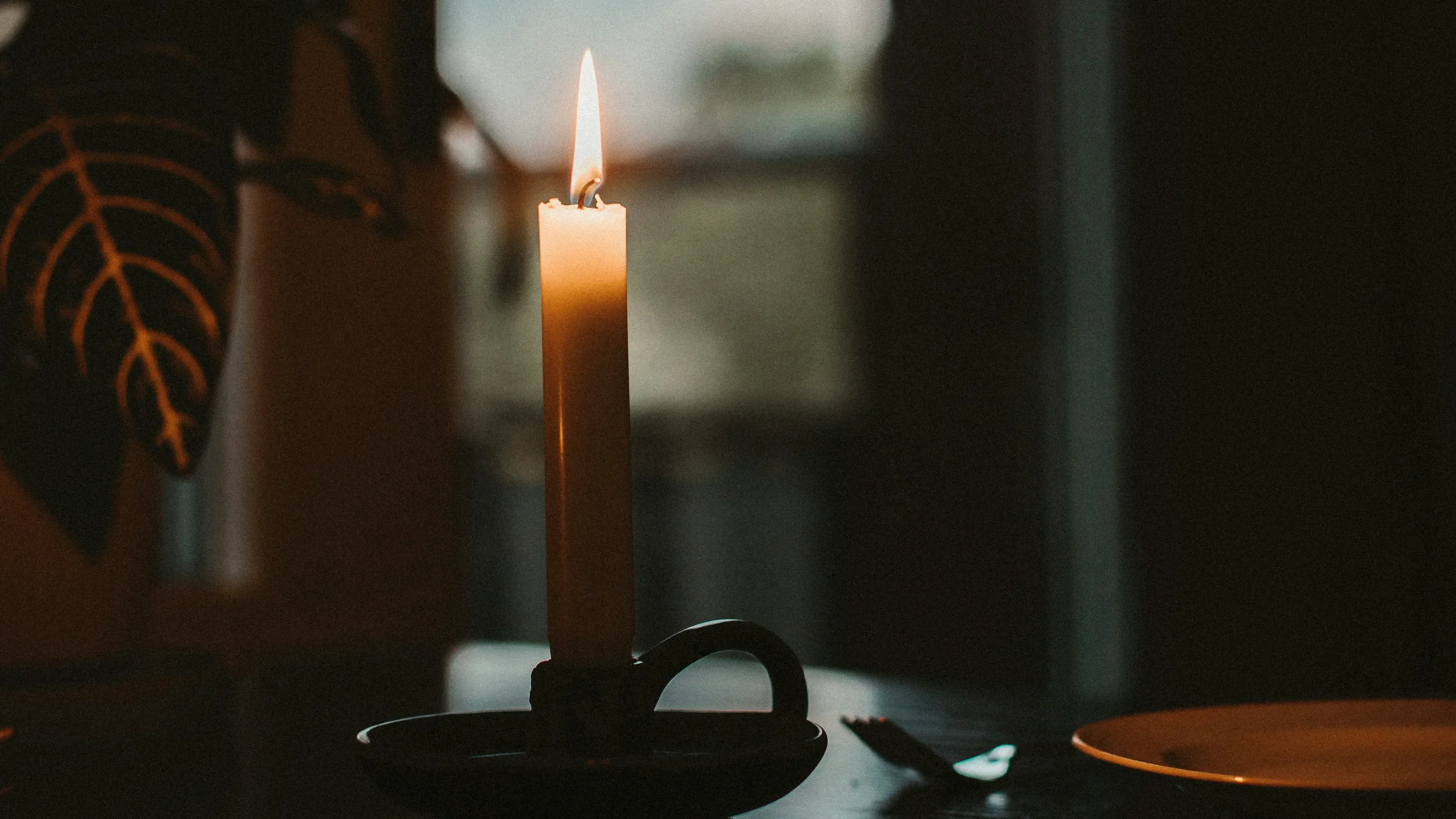 Lit candle sitting peacefully on side table in a room