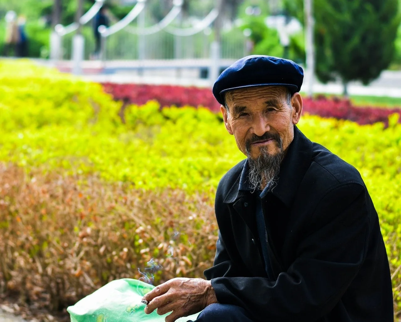 elderly man in front of a flower field like recovery after abuse