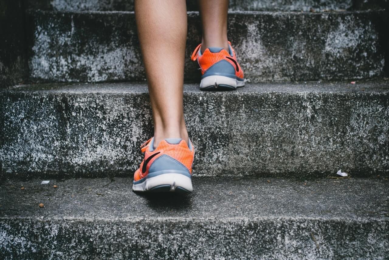 person in sneakers climbing stairs