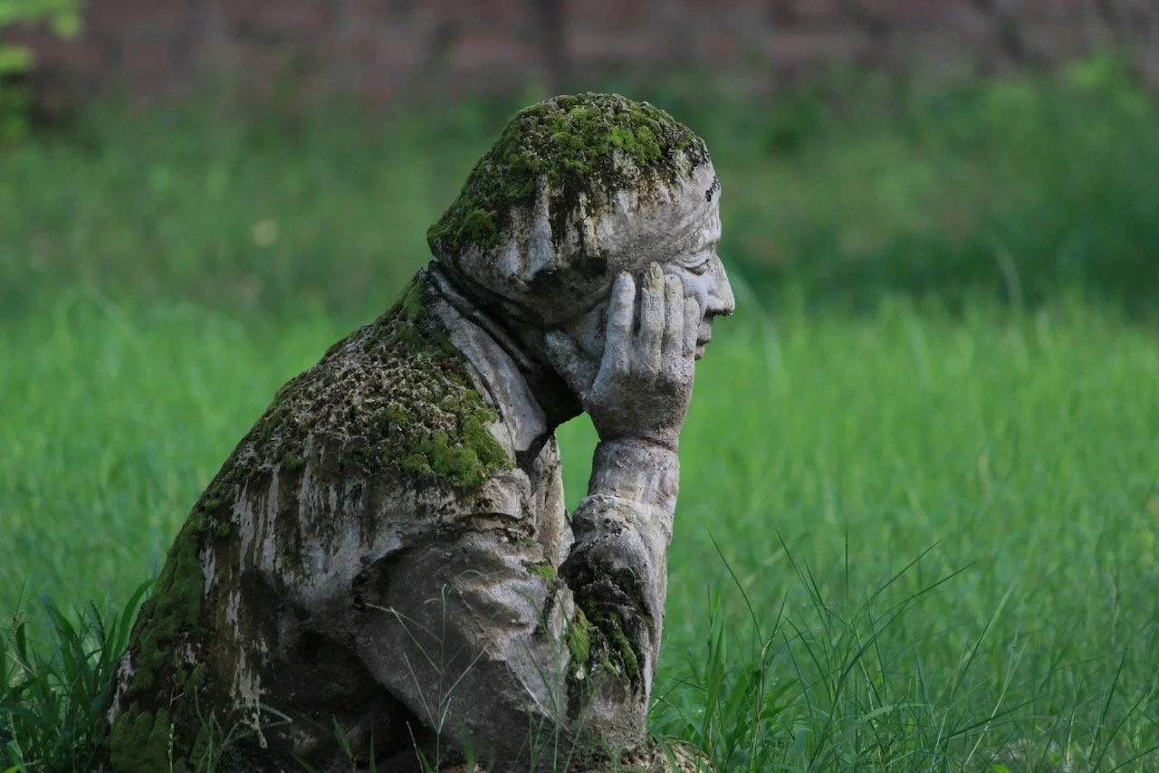 mossy statue of man looking into the future after betrayal trauma recovery