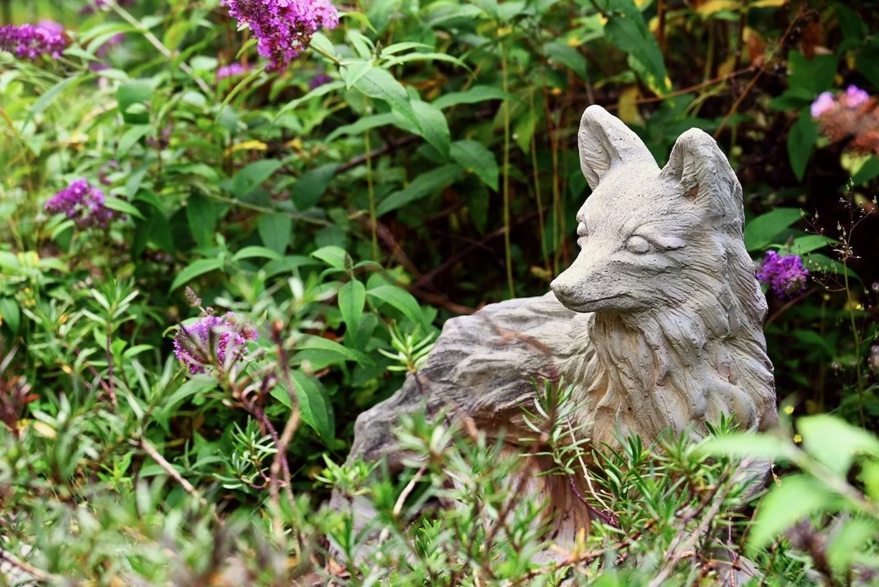 statue of fox looking at flowers symbolic of posttraumatic growth