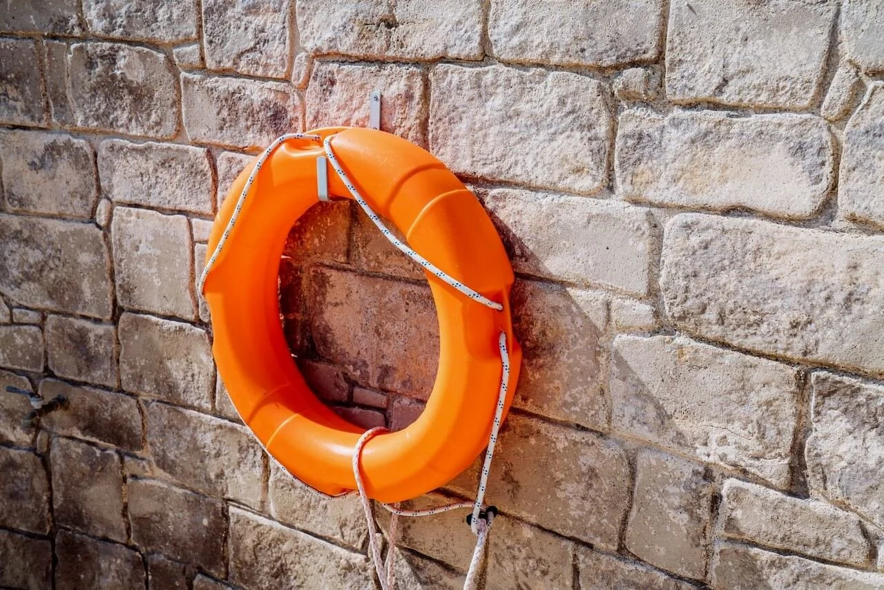 Life preserver on a stone wall like self care after betrayal trauma