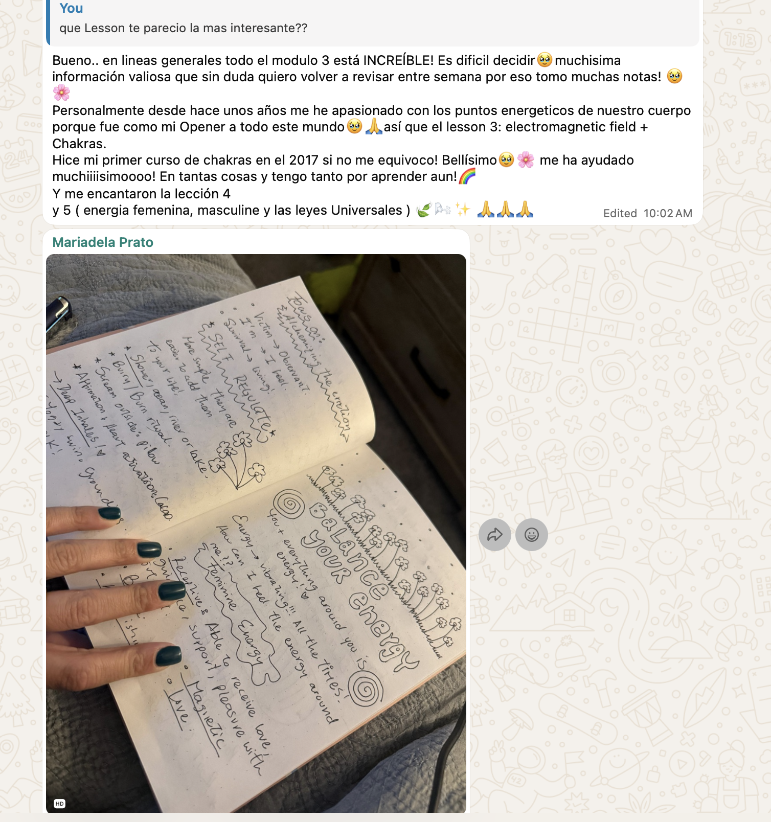 A notebook open to a page with handwritten notes and drawings, featuring the words 'Balance Your Energy' surrounded by clouds, spirals, and decorative elements. A person's hand with dark green nail polish is pointing at the page.