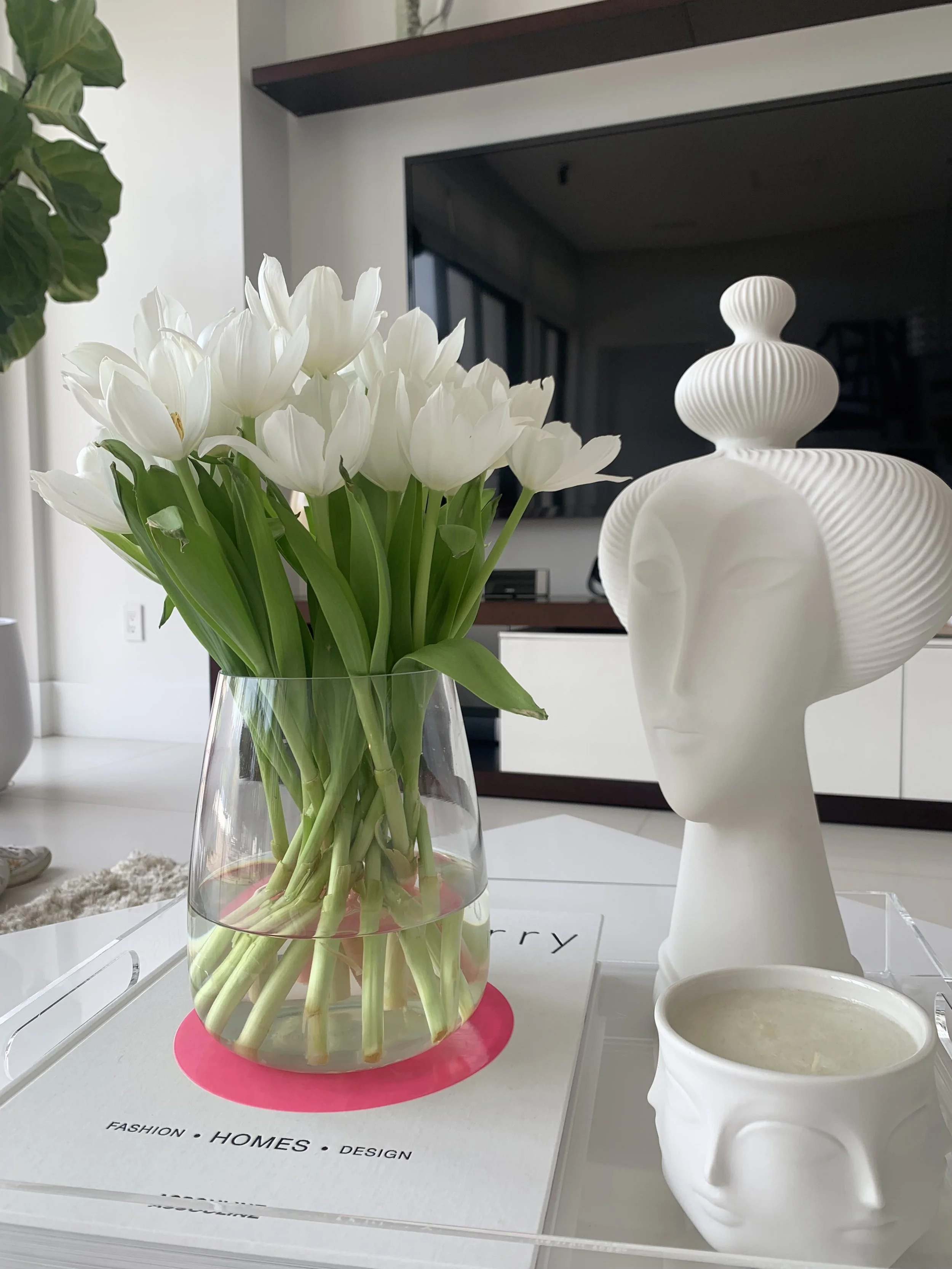 A full moon rising over the ocean at sunset with colorful pink, purple, and blue sky reflections on the water.