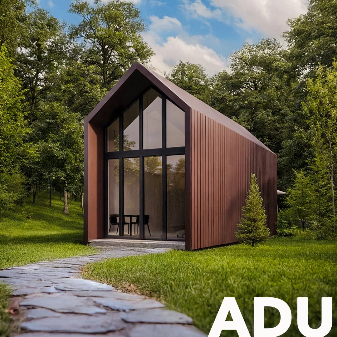 Modern A-frame house with large glass windows set in a lush green landscape with trees and a stone pathway.