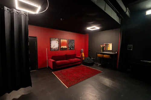 Blackout Studio lounge at STU 22, East London: deep red feature wall with velvet sofa and vintage decor