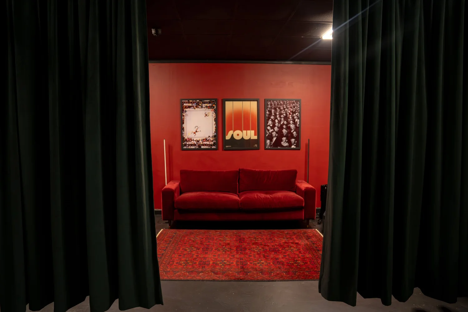 Full-height blackout drapes framing the red feature wall inside the STU 22 Blackout Studio in Wapping