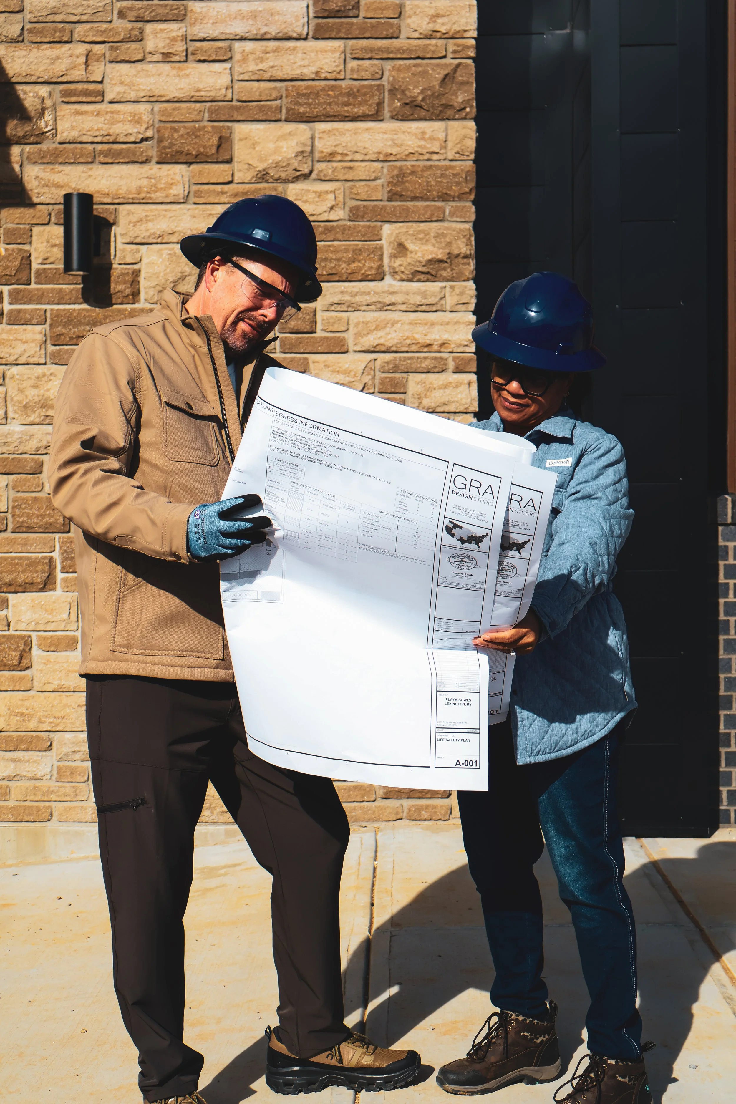 construction workers discussing blueprints, general contracting near me