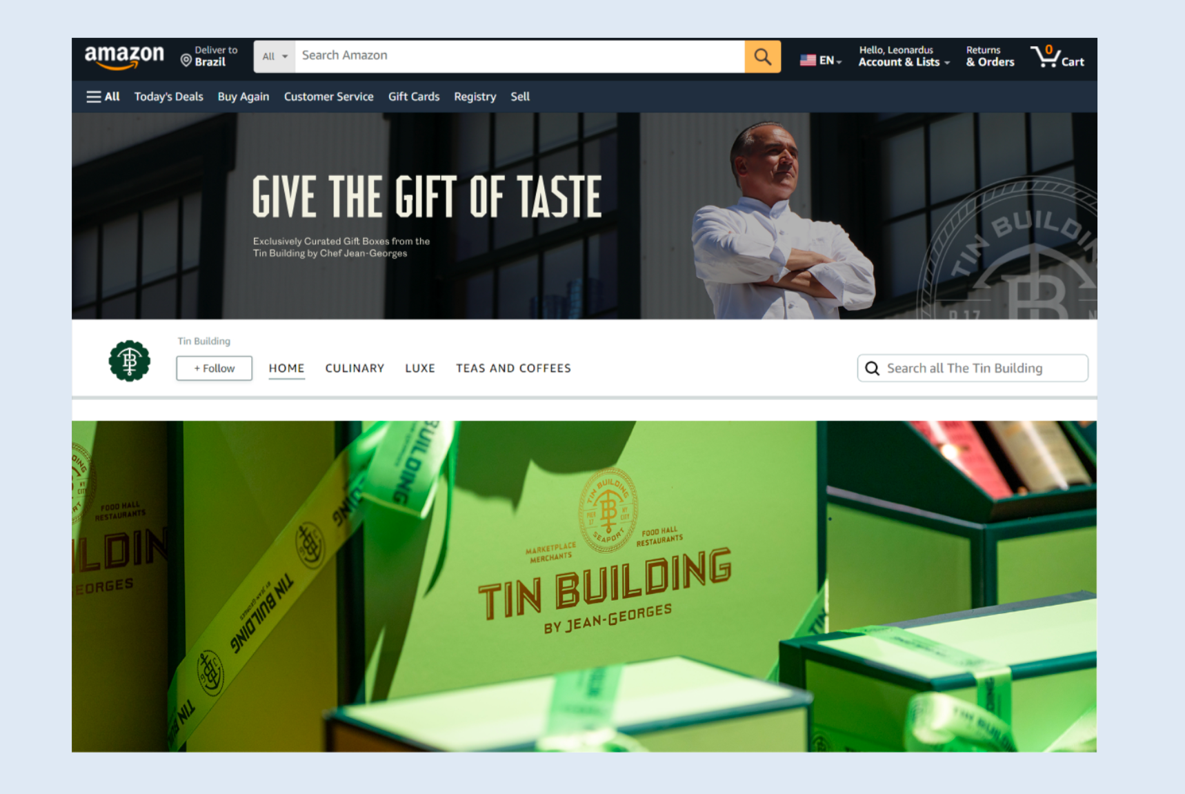 Amazon homepage featuring gift boxes from The Tin Building by Chef Jean-Georges, with a banner promoting tastefully curated gift boxes and a photo of a chef standing outside the building. Robert Ranfranz branding, design and ecommerce.