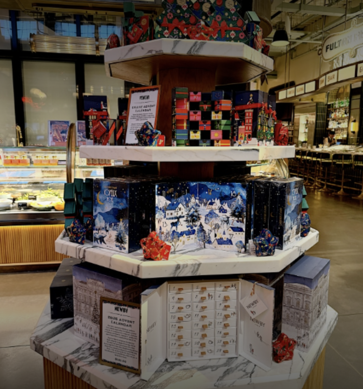Holiday-themed advent calendar display with colorful gift boxes and toys in a store.