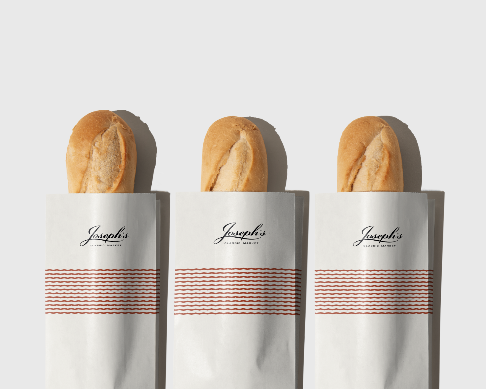 Three breadsticks in branded paper wrappers on a white background.