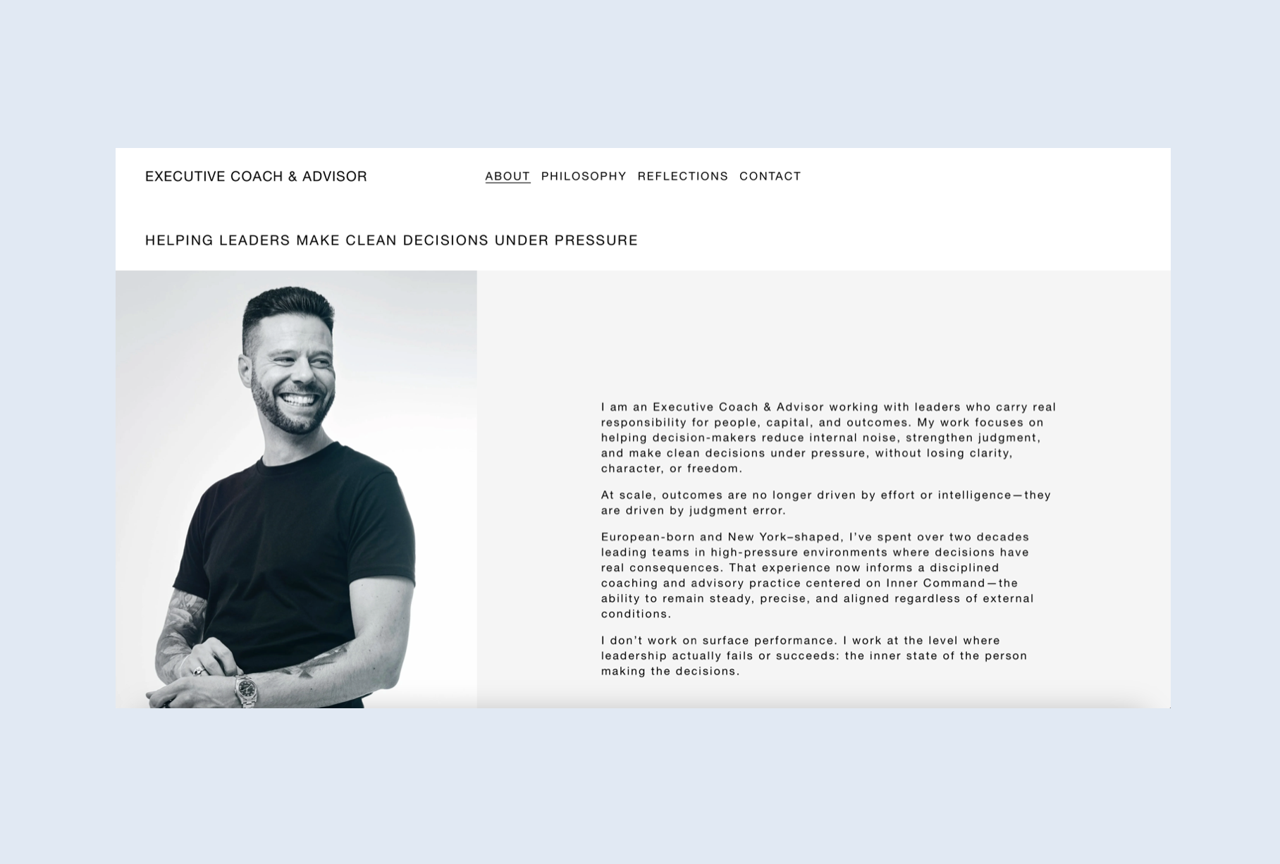 A man with a beard and tattoos on his left arm, smiling and standing with his arms crossed, wearing a black T-shirt and a watch. Robert Ranfranz branding, design and ecommerce.