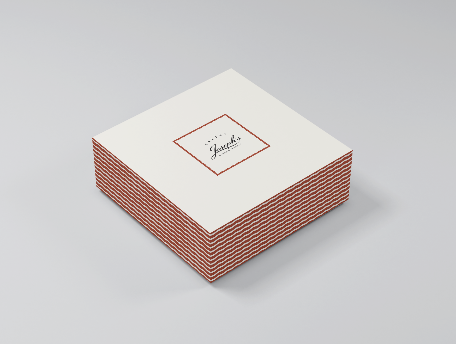 Stack of white boxes with red wavy stripes and a central white label with a red border, displaying the text "Joseph's Bakery" and "Grocery Market".
