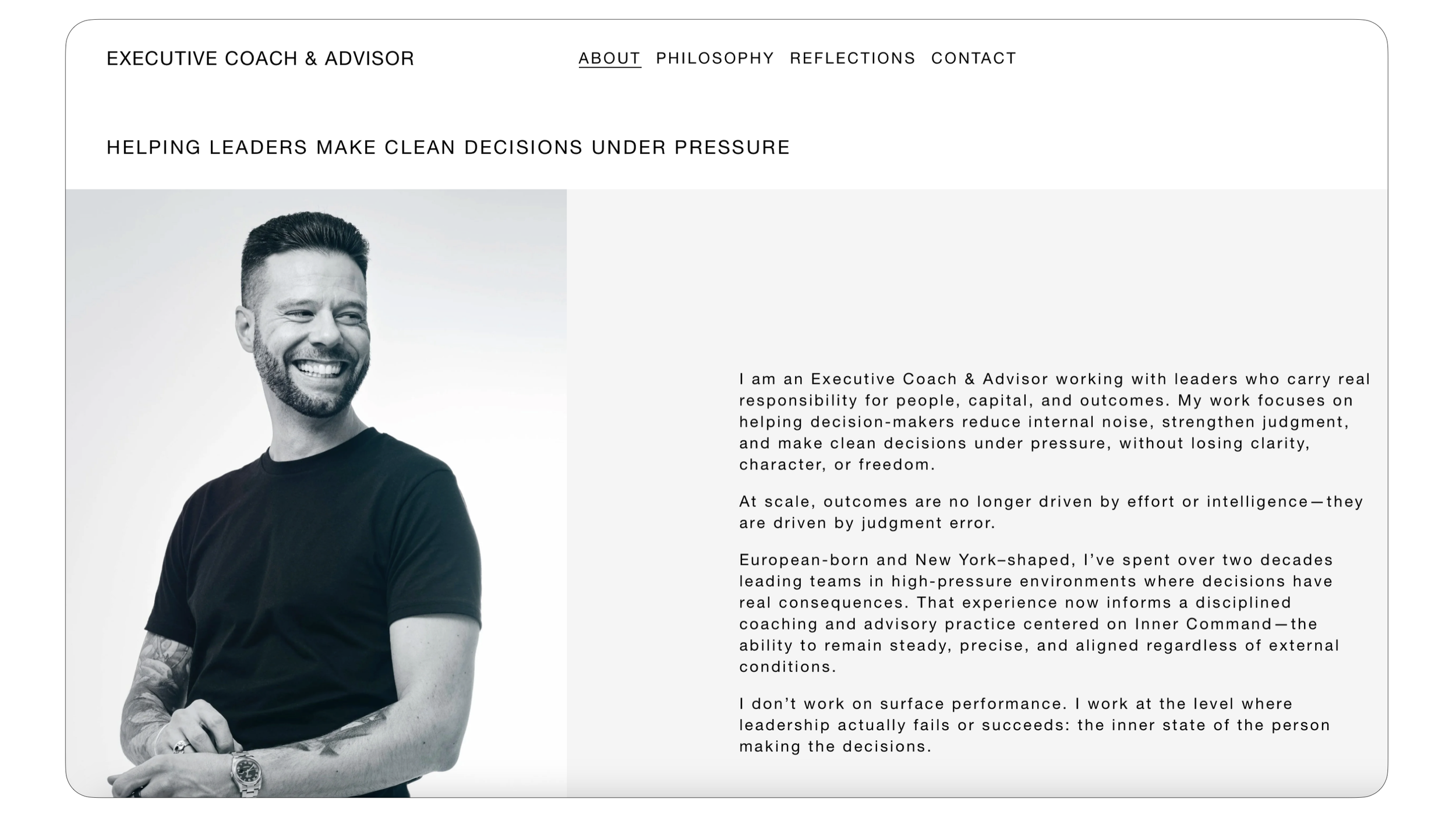 A man with tattoos on his left arm, dark hair, and a beard, wearing a black T-shirt, smiling and looking to his right. Robert Ranfranz creative studio.