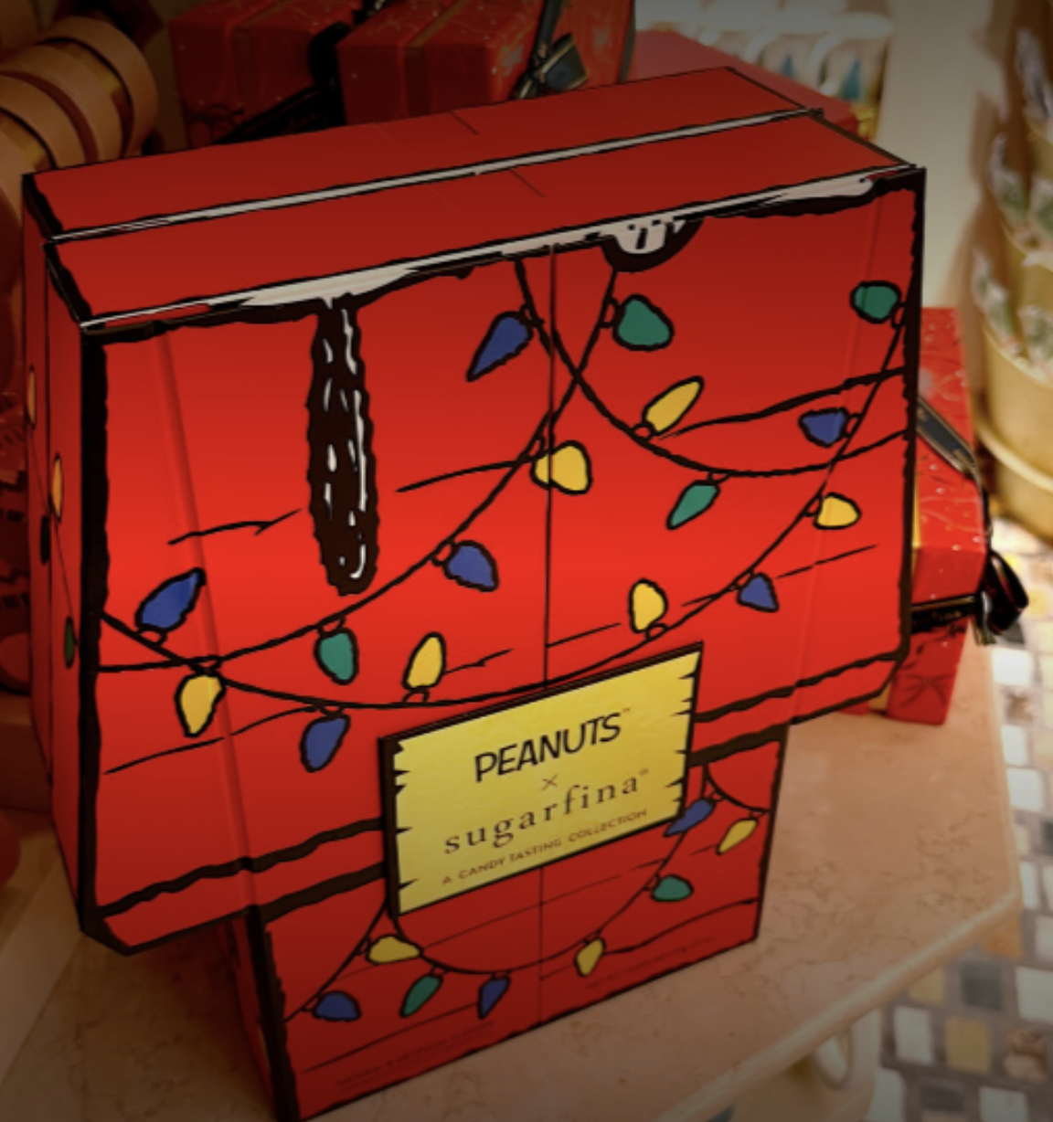 Red Peanuts x Sugarfina gift box decorated with illustrated colorful holiday string lights.
