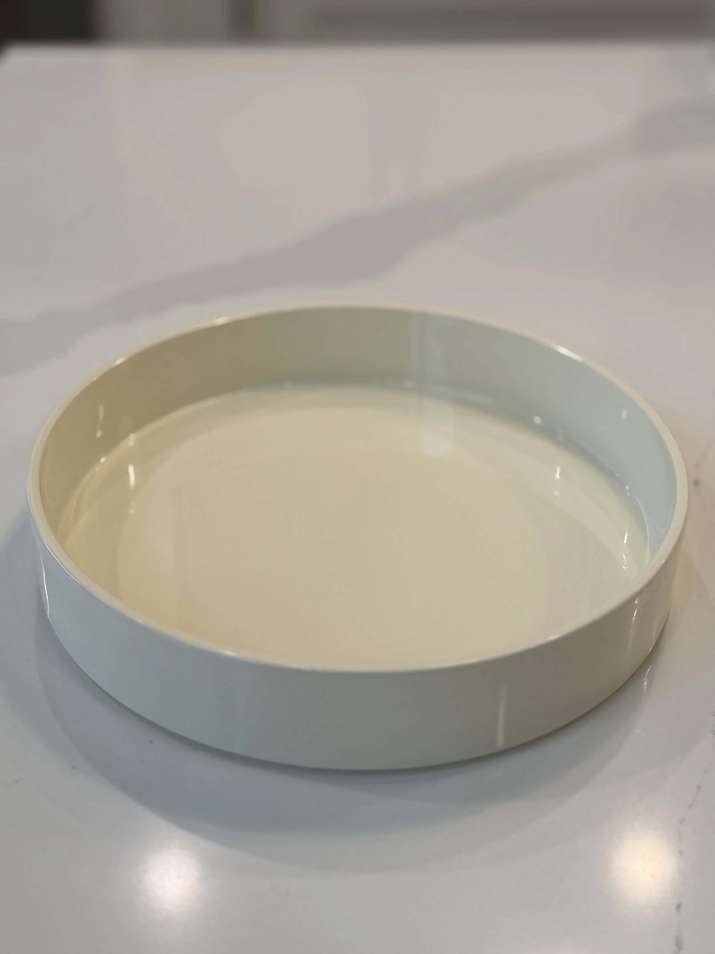 Close-up of a white washing machine drum filled with water, with the door open.