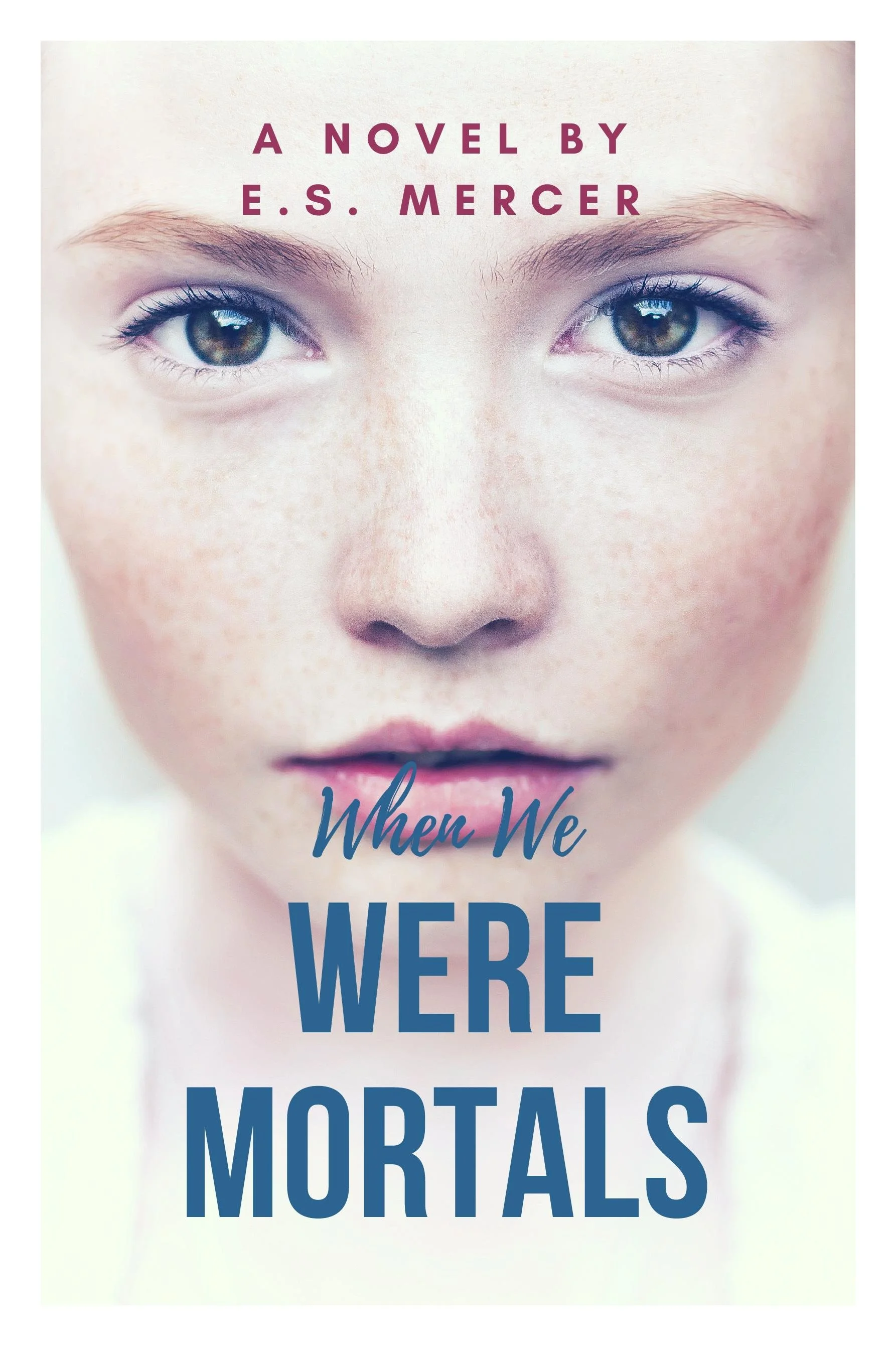 Close-up of a young girl's face with blue eyes, freckles, and soft pink lips, with the book title 'When We Were Mortals' and author name E.S. Mercer above her face.