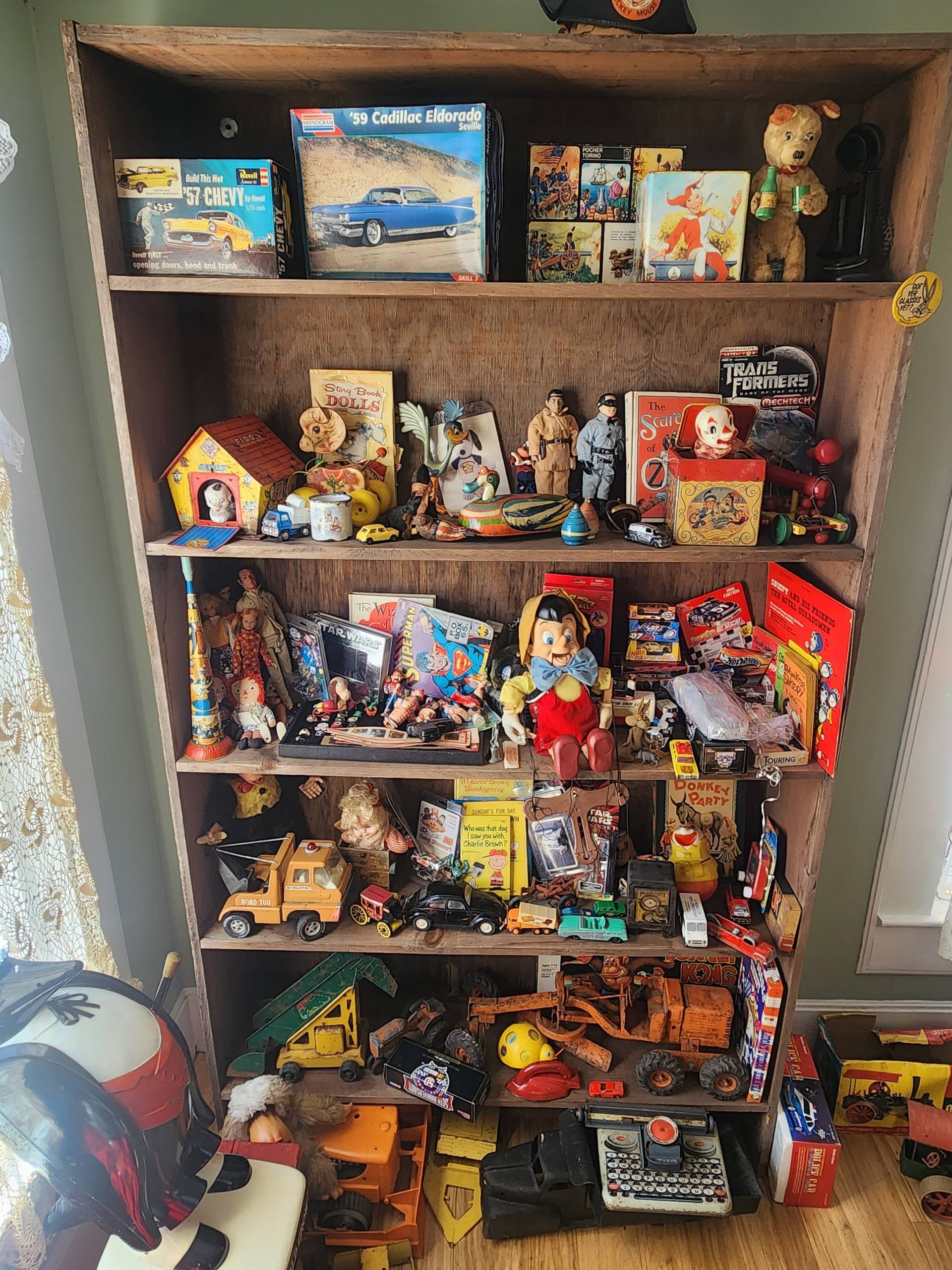 Bookshelf filled with antique toys.