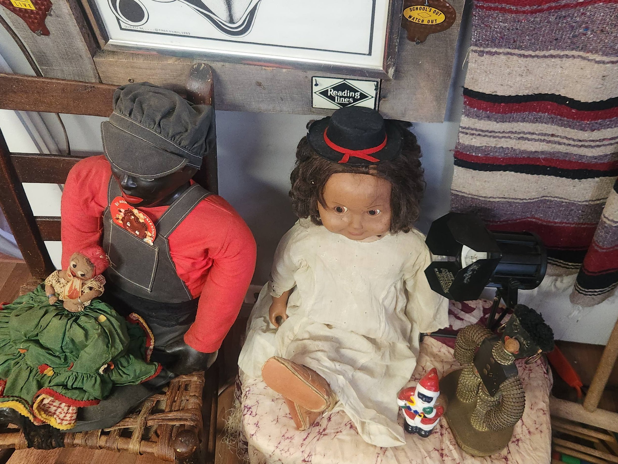 Antique Black dolls on full sized chairs.