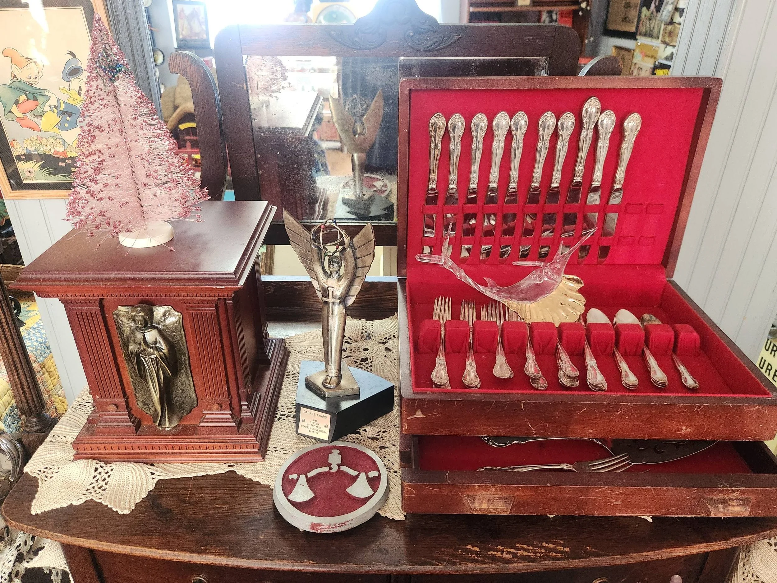 Antique music box, silver award statue, and silverware in a box.