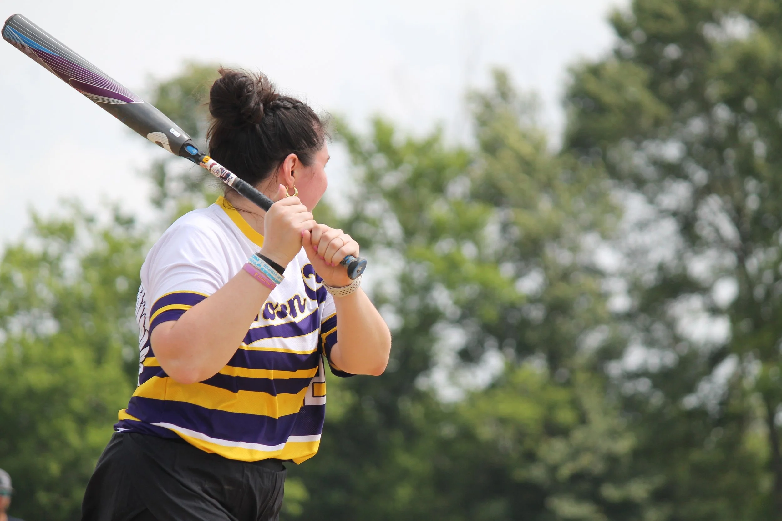 A woman holding a tennis racket preparing to hit a ball outdoors.