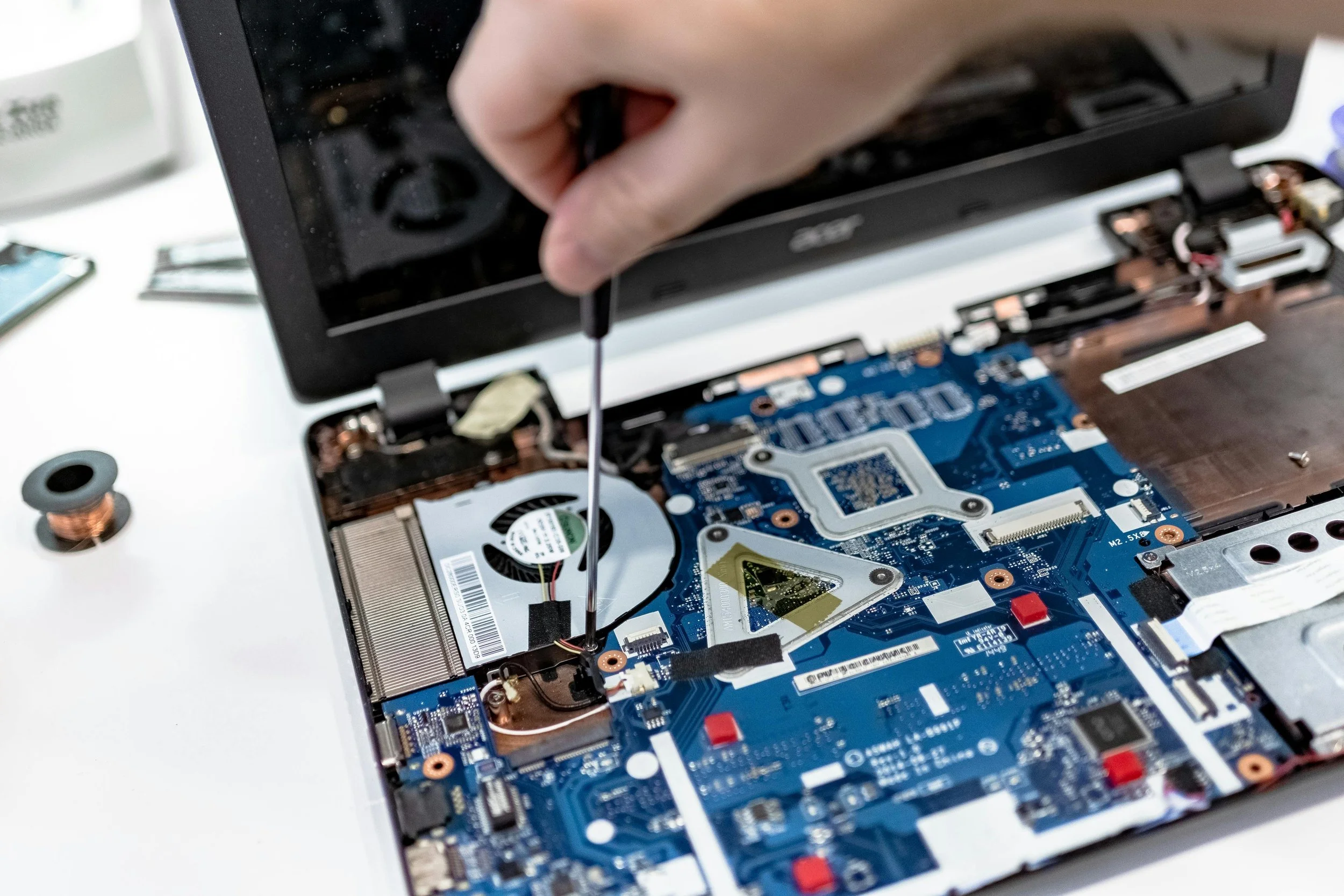 An IT tech working on installing a new drive in a laptop.