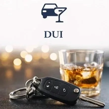 A glass of whiskey, car keys with remote, and a DUI warning sign with a driving under influence icon.