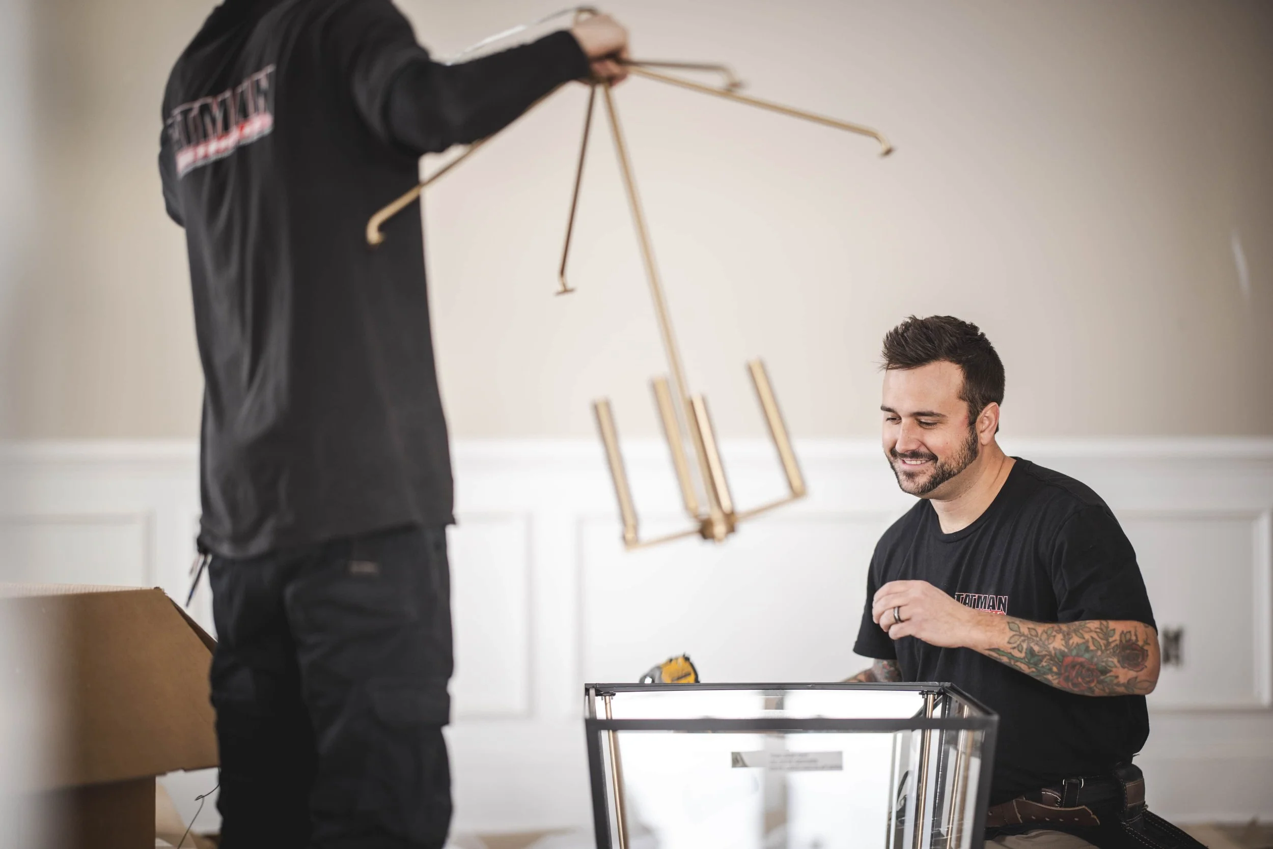Tatman Electric electricians installing brass pendant light fixture in high-end residential interior Pittsburgh PA