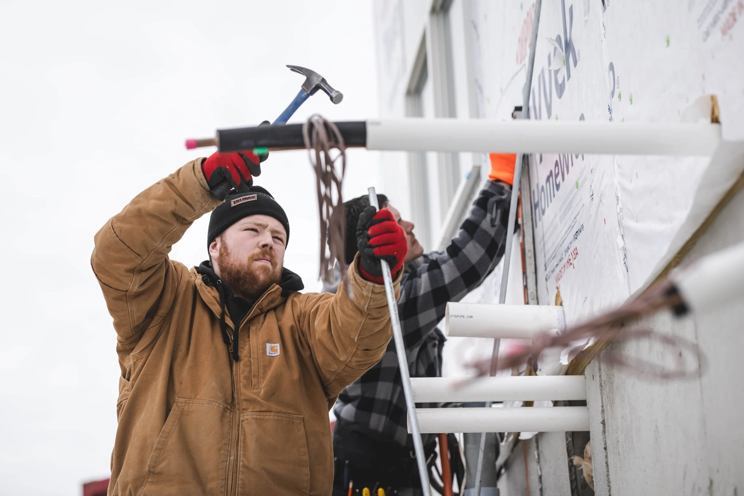 Tatman Electric workers installing exterior electrical conduit on residential new construction job site Pittsburgh PA