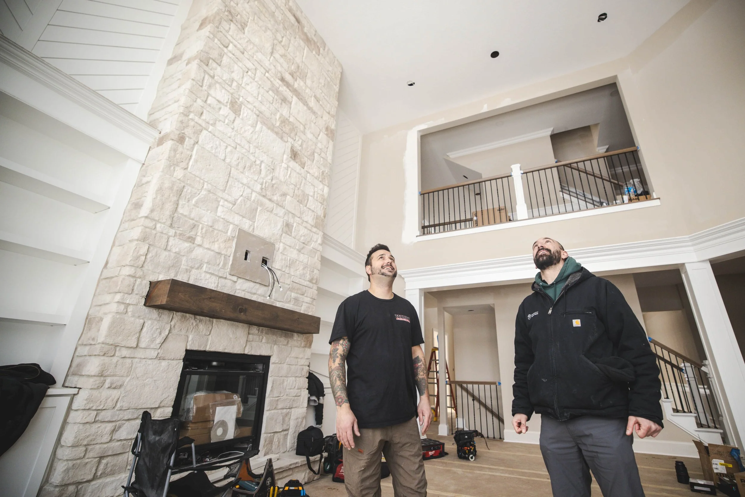 Tatman Electric electricians inspecting high-end residential renovation interior with stone fireplace Pittsburgh PA