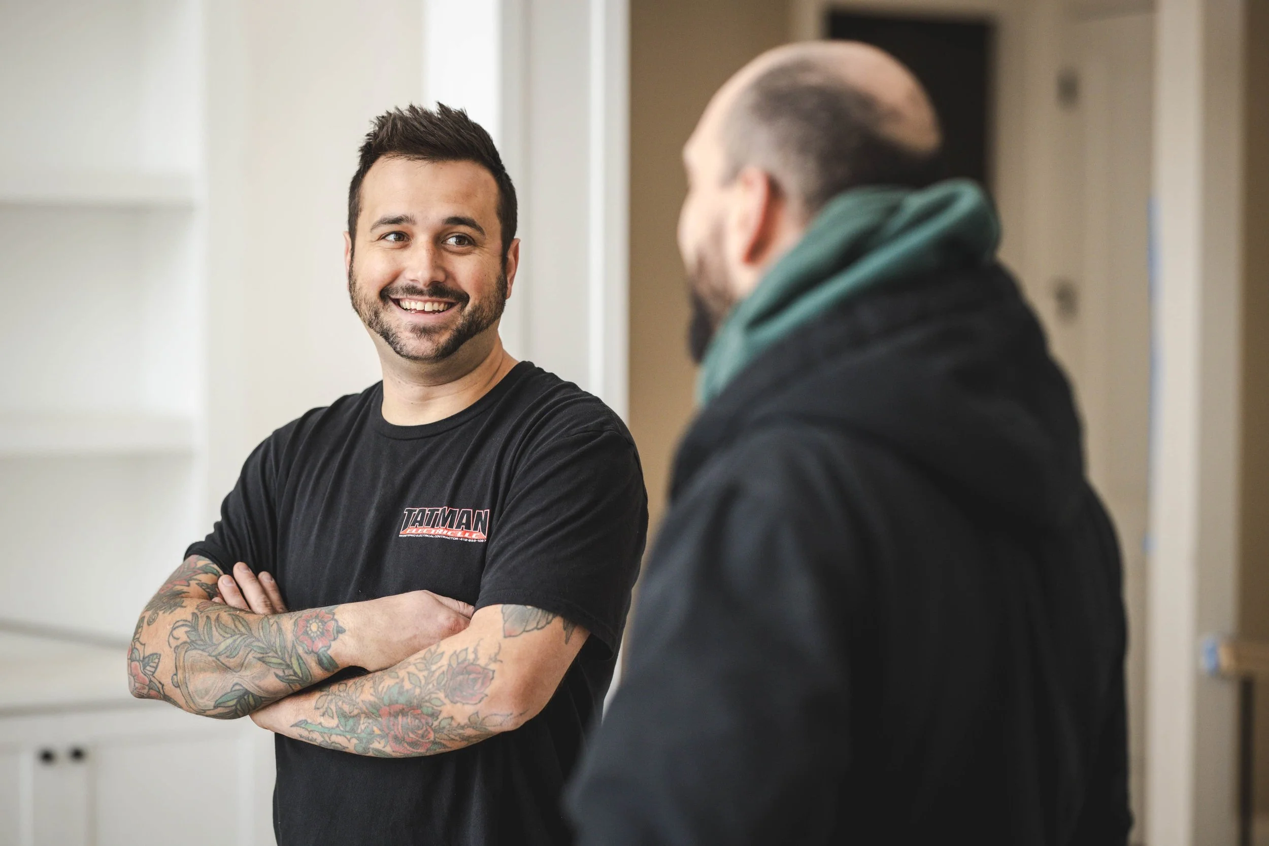 Tatman Electric owner Dan Tatman smiling with arms crossed on residential construction job site Pittsburgh PA