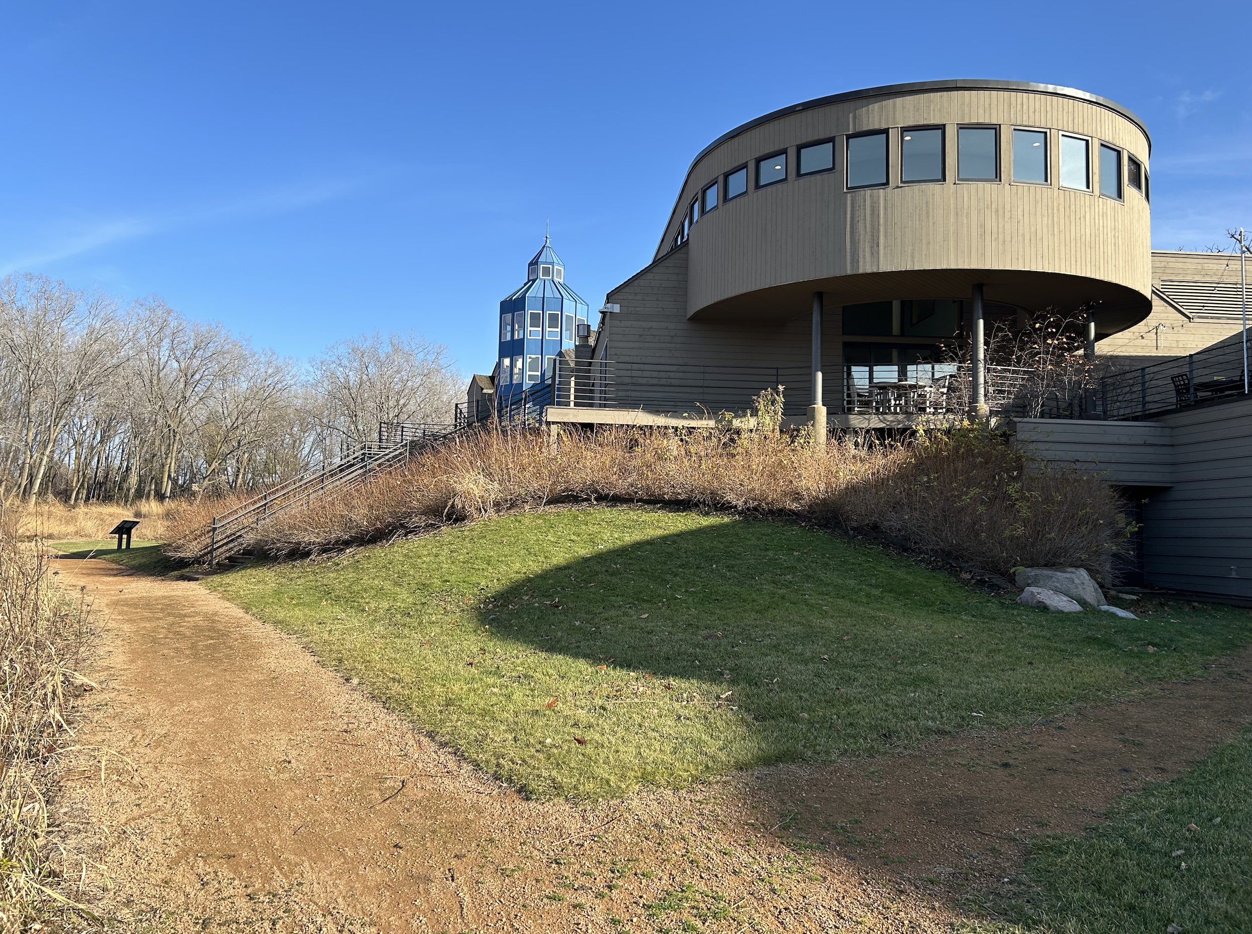 Outdoor image of the Marsh wellness center including landscaped yard with a pathway, leafless trees, and a clear blue sky.