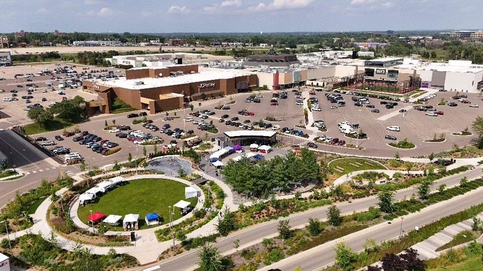 Aerial view of a Ridgedale shopping mall with parking lots, a green park area, and surrounding roads.