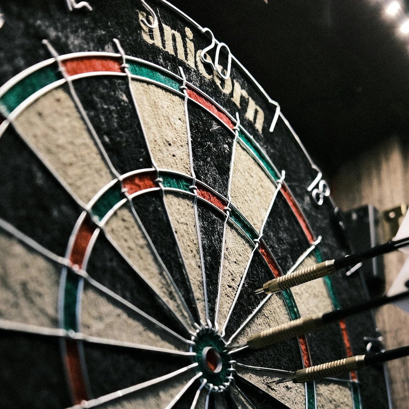 Close-up of a dartboard with darts hitting the scoring area, showing the number 20 and the surrounding sections.