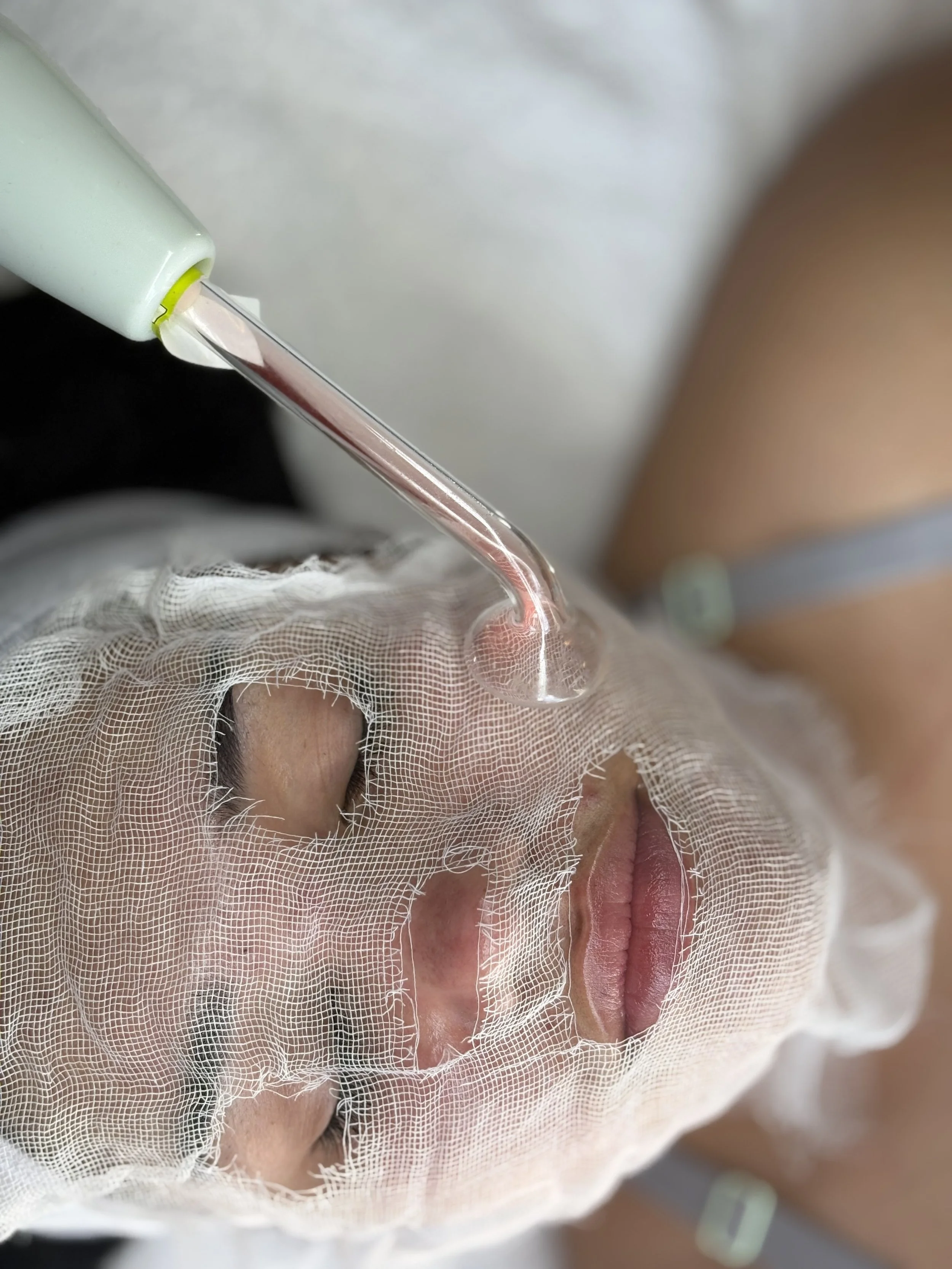 Client receiving a professional facial treatment with serum application at ran with beauty skin care studio