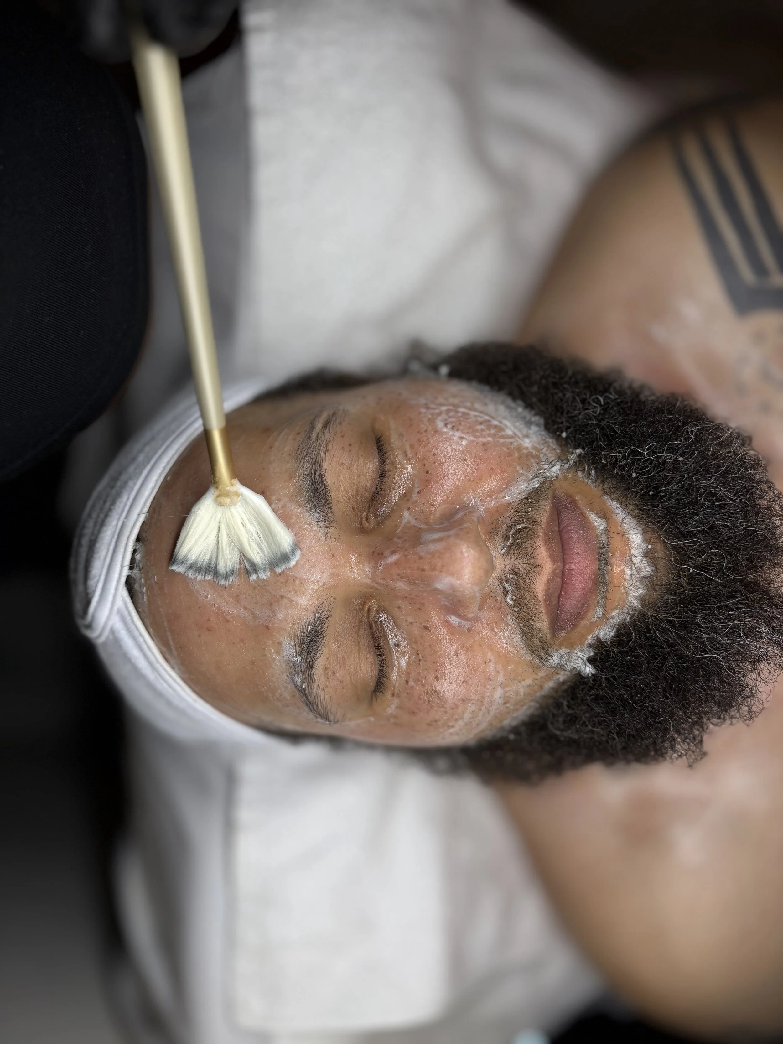 Male client receiving a professional facial treatment from a license esthetician at ran with beauty skincare studio