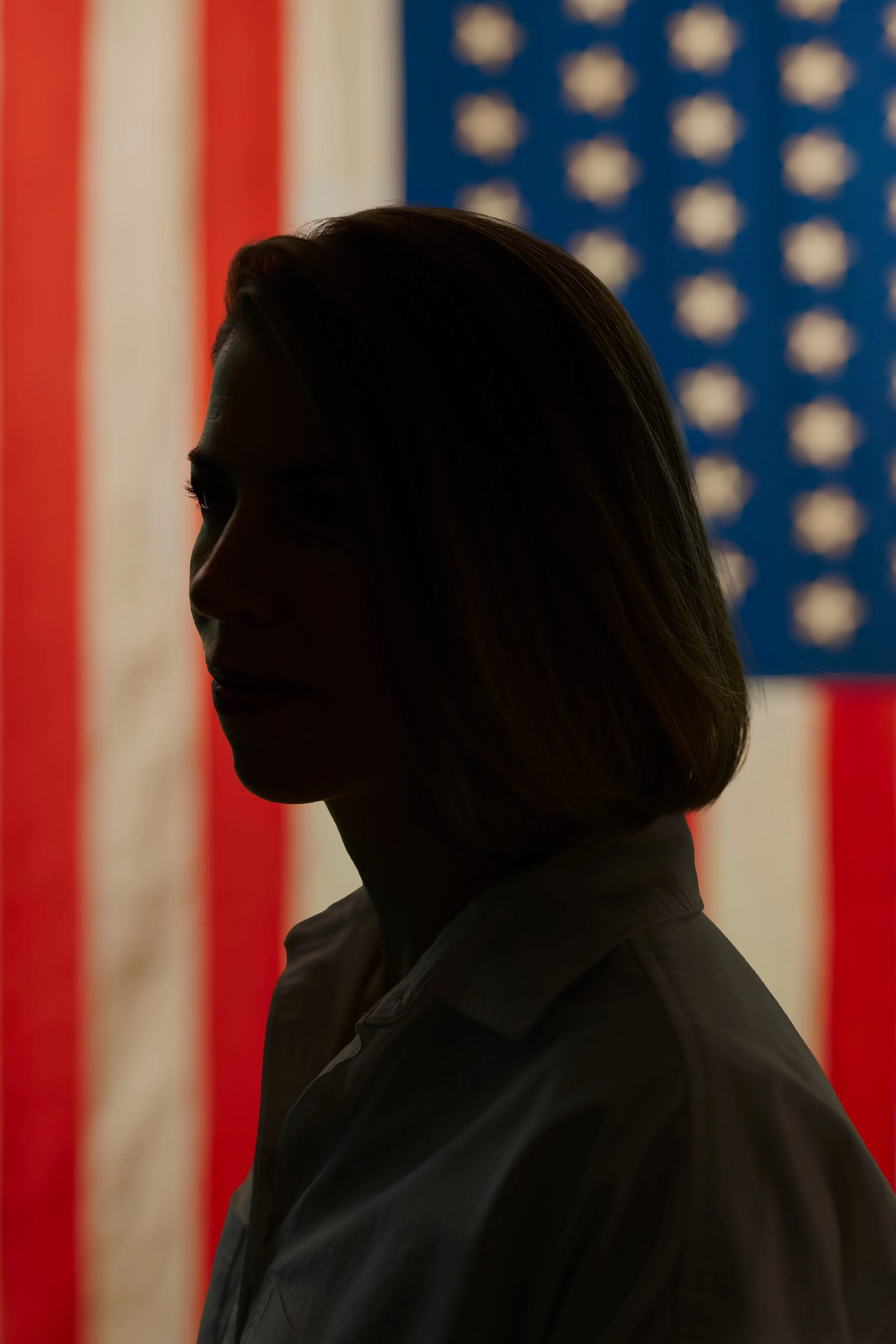 Silhouette of a woman with an American flag in the background.