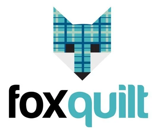 A stylized fox head made of blue plaid quilt pattern above the text 'fox guilt' with 'fox' in black and 'guilt' in light blue.