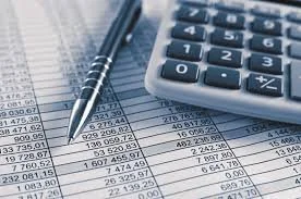 Close-up of financial documents with a calculator, pen, and spreadsheets showing numerical data.