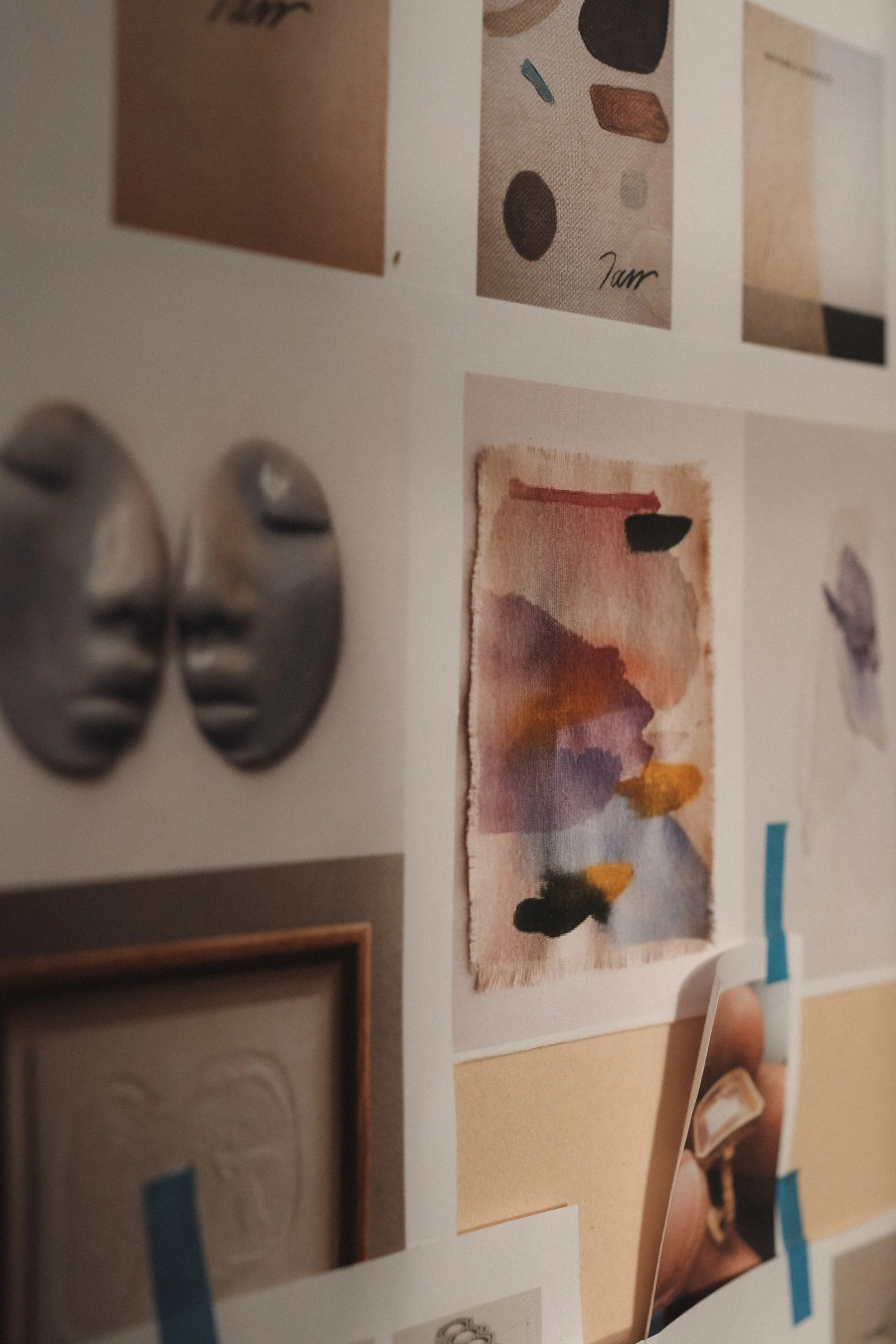 Collage de diverses œuvres d'art, y compris des peintures abstraites, des sculptures et des photographies, fixées sur un tableau avec du ruban adhésif.