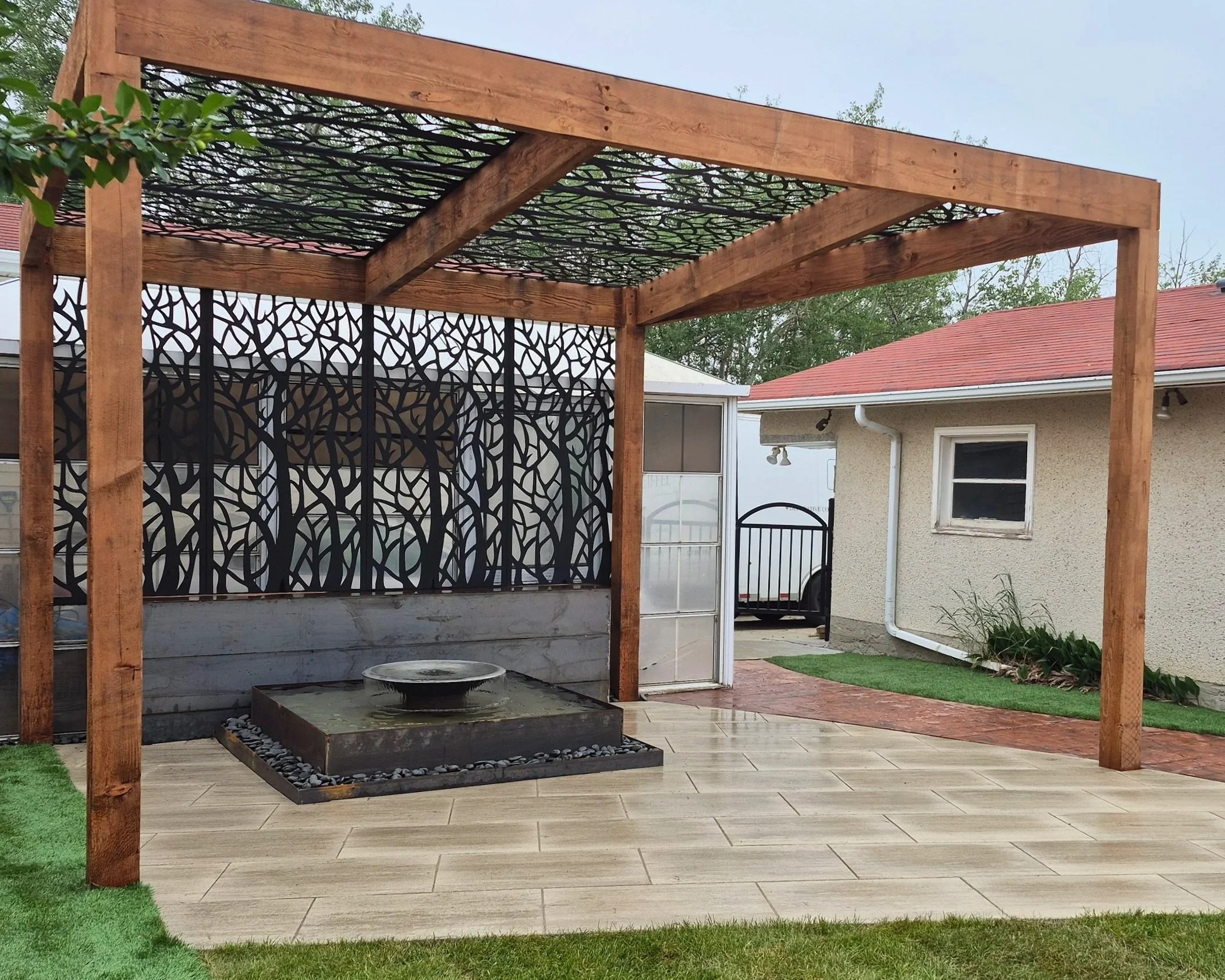 Custom wooden pergola with metal decorative elements, custom water feature, fountain, pavers patio, paving stones