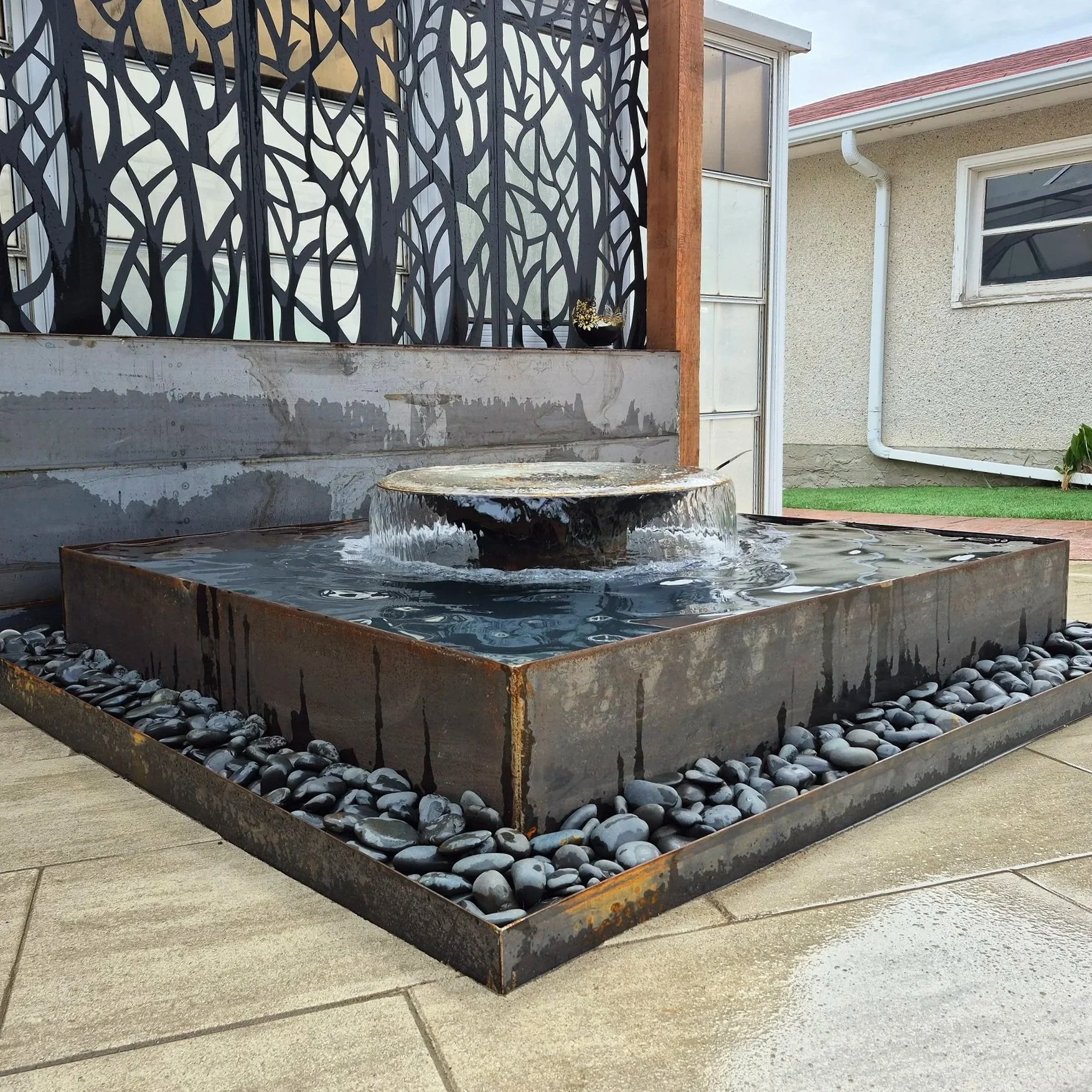 Custom water feature, fountain, wood and metal pergola, paving stones, pavers, patio