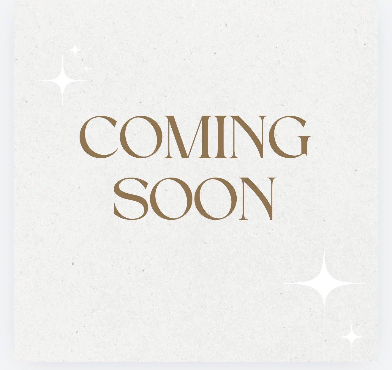 White card with gold lettering saying 'Coming Soon' and sparkles in corners.