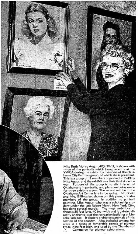 Black and white photo showing Ruth Monro Augur hanging three portraits of women on a wall, smiling at the camera. The portraits are paintings or photographs of women.