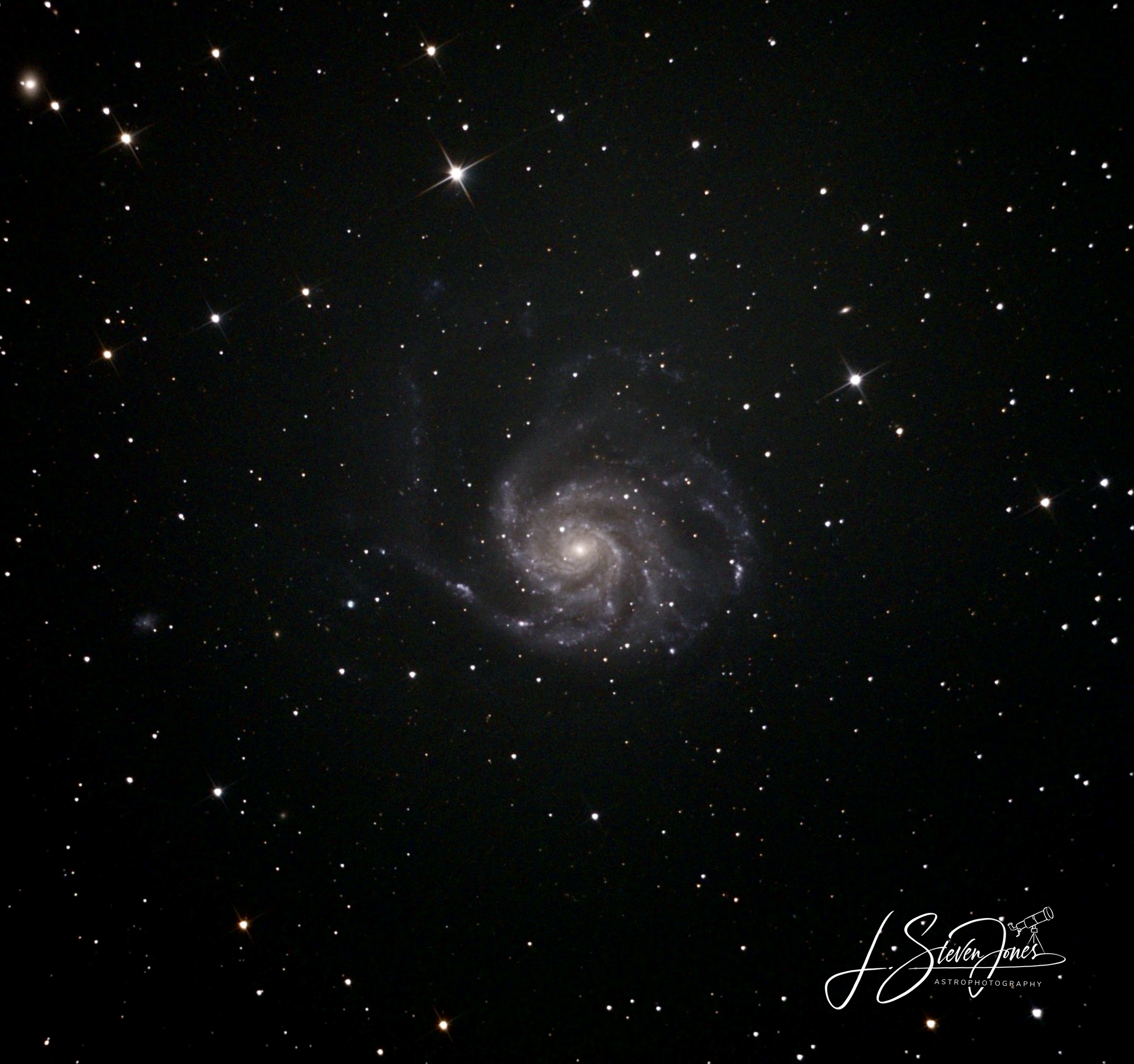 Astrophotography image of a spiral galaxy.  The photographers stamp is in the lower right.