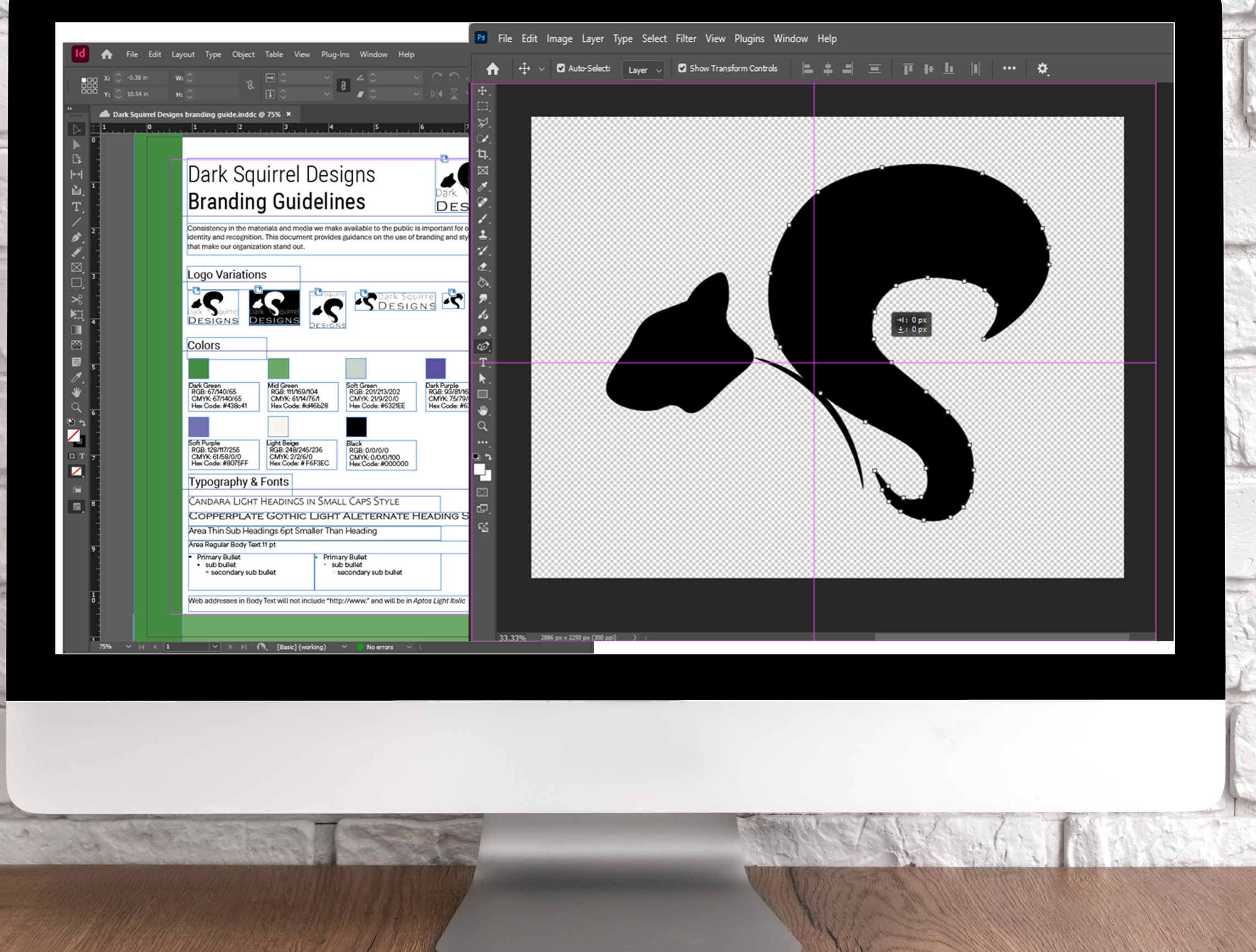 A computer monitor on a desk displaying a branding guide being created with InDesign and a logo being designed with Photoshop