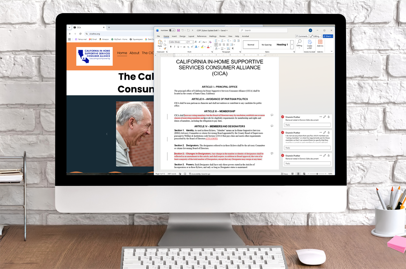 A desktop computer on a wooden desk shows a webpage and a document open on the screen; the document appears to be a policy document from the California In-Home Supportive Services Consumer Alliance in the process of being edited.