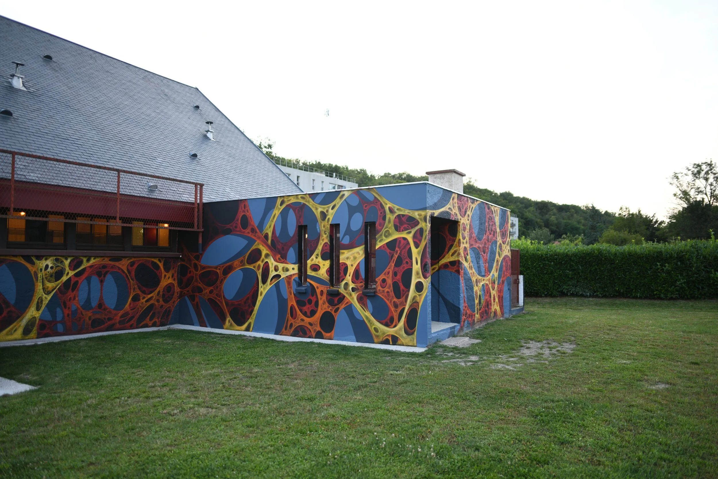 Détail de la peinture murale évoquant le verre en fusion et les facettes colorées inspirées des vitraux de la Maison des Verriers.